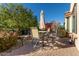 Small patio with table and chairs set, next to a lush garden at 21720 N 265Th Dr, Buckeye, AZ 85396