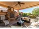 Relaxing patio with fireplace, seating area and ceiling fan at 21720 N 265Th Dr, Buckeye, AZ 85396