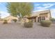 Spacious backyard with gravel, mature trees, and partial home view at 22915 N Wagon Wheel Dr, Sun City West, AZ 85375