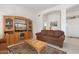 Living room with a brown couch and wooden entertainment center at 22915 N Wagon Wheel Dr, Sun City West, AZ 85375