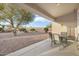 Covered patio with table and chairs, overlooking a gravel backyard at 22915 N Wagon Wheel Dr, Sun City West, AZ 85375