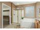 Bathroom features a large soaking tub, glass shower, and walk-in closet at 23313 N De La Guerra Ct, Sun City West, AZ 85375