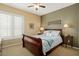 Comfortable bedroom with wood sleigh bed and window shutters at 23313 N De La Guerra Ct, Sun City West, AZ 85375