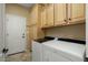 Laundry room with washer, dryer, and overhead cabinets at 23313 N De La Guerra Ct, Sun City West, AZ 85375