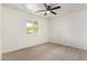 A bright, carpeted bedroom features a ceiling fan and view to the outside through a window at 2345 W Monroe St # 4, Phoenix, AZ 85009