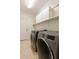 Convenient laundry room with modern washer and dryer, plus built-in storage cabinets at 2471 E Jade Dr, Chandler, AZ 85286