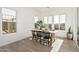 Sunlit dining area with a wooden table and black chairs near large windows at 2553 E Virginia Cir, Mesa, AZ 85213