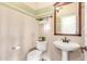 Clean and bright half bathroom with pedestal sink and wood framed mirror at 29405 W Columbus Ave, Buckeye, AZ 85396