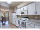 Kitchen with white cabinets, granite countertops and a view into the adjacent living area at 3270 S Goldfield Rd # 816, Apache Junction, AZ 85119