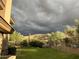 Spacious backyard featuring well-maintained lawn and desert plants under a dramatic sky at 3439 E Tonto Dr, Phoenix, AZ 85044