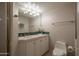 This bathroom has a vanity with a sink, toilet, and tiled walls at 3439 E Tonto Dr, Phoenix, AZ 85044