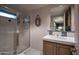 Bathroom featuring glass shower with tile surround, vanity, decorative mirror, and tile floors at 3439 E Tonto Dr, Phoenix, AZ 85044