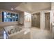 Bathroom featuring soaking tub, walk in shower, and double vanity with stone counters at 3439 E Tonto Dr, Phoenix, AZ 85044