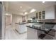 This kitchen features white cabinets, tile flooring, granite countertops and a kitchen island with bar seating at 3439 E Tonto Dr, Phoenix, AZ 85044