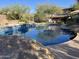 Inviting pool with rock features and desert landscaping enhances the outdoor space at 3439 E Tonto Dr, Phoenix, AZ 85044