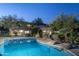 Twilight view of a beautiful backyard pool area highlighting the lush landscaping at 3439 E Tonto Dr, Phoenix, AZ 85044