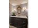 Charming powder room featuring a decorative mirror, stylish wallpaper, and elegant fixtures for a touch of luxury at 3439 E Tonto Dr, Phoenix, AZ 85044