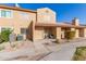 Tan two-story stucco home with front patio, two chairs, and landscaping at 3511 E Baseline Rd # 1206, Phoenix, AZ 85042