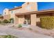 Tan two-story stucco home with front patio, two chairs, and landscaping at 3511 E Baseline Rd # 1206, Phoenix, AZ 85042