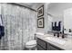 Bathroom featuring a gray vanity, toilet, sink, decorative shower curtain, and framed artwork at 3843 E Old Stone N Cir, Chandler, AZ 85249