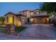 Elegant two-story home with a three-car garage and manicured front lawn at dusk at 3843 E Old Stone N Cir, Chandler, AZ 85249