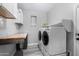 Bright laundry room with wooden countertops, white cabinets, and modern washer/dryer units at 3843 E Old Stone N Cir, Chandler, AZ 85249