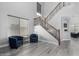 Bright living room with wood-look floors, tall ceilings, large window and a staircase with wooden railing at 3843 E Old Stone N Cir, Chandler, AZ 85249