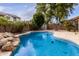 Sparkling blue pool with rock features, lush landscaping and privacy fence at 3843 E Old Stone N Cir, Chandler, AZ 85249