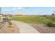 Curved concrete pathway meanders through a grassy park area at 39995 W Agave Rd, Maricopa, AZ 85138