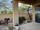 Covered back patio featuring a dining table, grill, and peaceful garden views, ideal for outdoor dining at 42225 N Celebration Way, Phoenix, AZ 85086