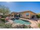 Backyard featuring a pristine pool, spa, covered patio, and lush landscaping for outdoor enjoyment at 42225 N Celebration Way, Phoenix, AZ 85086