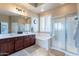 Elegant bathroom with large mirror, double sinks, soaking tub and glass shower at 42225 N Celebration Way, Phoenix, AZ 85086