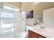 Bright bathroom with glass enclosed shower, single sink vanity with dark wood cabinets and a large mirror at 42225 N Celebration Way, Phoenix, AZ 85086