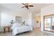 Bright bedroom features a ceiling fan, sliding glass doors, and tiled floors at 42225 N Celebration Way, Phoenix, AZ 85086