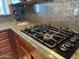 Granite countertops complement the cooktop with stylish knobs in the kitchen at 42225 N Celebration Way, Phoenix, AZ 85086