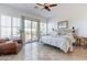 Bright main bedroom featuring white bedding, shutters, a ceiling fan, and an outdoor patio at 42225 N Celebration Way, Phoenix, AZ 85086