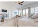 Bright main bedroom featuring white bedding, shutters, a ceiling fan, and an outdoor patio at 42225 N Celebration Way, Phoenix, AZ 85086