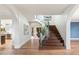 Bright foyer features a curved staircase, hardwood floors, and elegant design details at 6039 E Laurel Ln, Scottsdale, AZ 85254