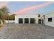 Modern three-car garage with black doors and gold accents set against a colorful dusk sky at 6039 E Laurel Ln, Scottsdale, AZ 85254