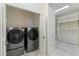 Modern laundry room with front loading washer and dryer and a closet with custom shelving and drawer units at 6039 E Laurel Ln, Scottsdale, AZ 85254