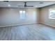 Open living area with gray vinyl plank flooring, large windows and ceiling fan at 7150 W Montecito Ave, Phoenix, AZ 85033