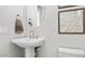 Stylish powder room with pedestal sink, gold fixtures, and framed art at 7439 W Whitehorn Trl, Peoria, AZ 85383