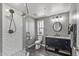 A neutral toned bathroom with tiled shower, modern vanity, framed mirror, and toilet at 7743 E Roosevelt St, Scottsdale, AZ 85257