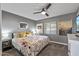 Cozy bedroom featuring a ceiling fan, plush carpeting, and a brightly colored floral bedspread at 7743 E Roosevelt St, Scottsdale, AZ 85257