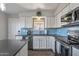 Bright kitchen with stainless steel appliances, white cabinets, an island, and modern lighting at 7743 E Roosevelt St, Scottsdale, AZ 85257