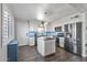 Modern kitchen featuring stainless steel appliances, white cabinets, an island, and hardwood floors at 7743 E Roosevelt St, Scottsdale, AZ 85257