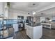 Stylish kitchen features stainless steel appliances, white cabinets, an island, and hardwood floors at 7743 E Roosevelt St, Scottsdale, AZ 85257