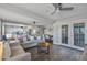 Bright living room with french doors, hardwood floors, and a view of the open concept kitchen and dining area at 7743 E Roosevelt St, Scottsdale, AZ 85257