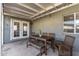 Cozy covered patio featuring a wooden dining set, string lights, and access to the backyard at 7743 E Roosevelt St, Scottsdale, AZ 85257