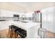 White kitchen with an island, stainless steel appliances, and a tile backsplash at 7908 W Rose Garden Ln, Peoria, AZ 85382